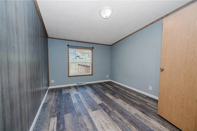 a view of empty room with wooden floor