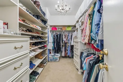 a view of walk in closet with clothes