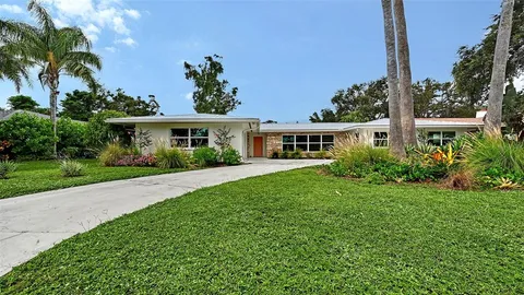 a front view of a house with a yard and potted plants