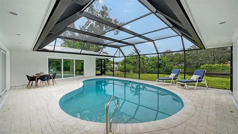 a view of a swimming pool with a table and chairs under an umbrella