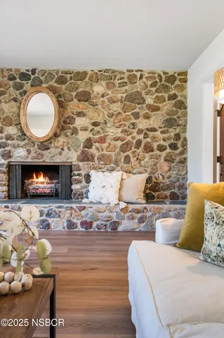 a dining room with wooden floor a chandelier a glass table and chairs