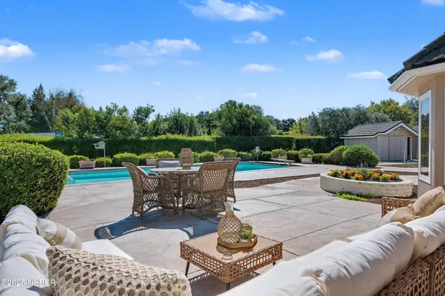 a view of a swimming pool with a patio and a yard