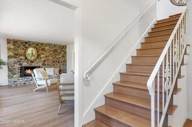 a living room with furniture a fireplace and a large window
