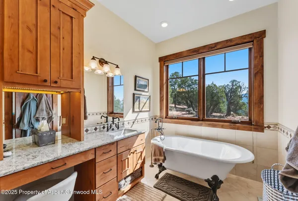 a bathroom with a granite countertop sink and a large mirror