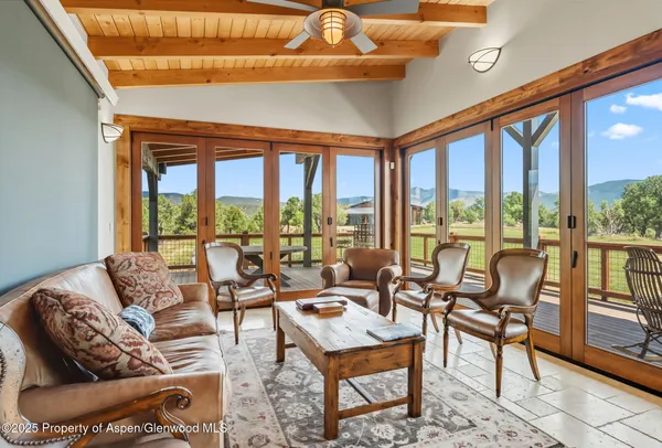 a living room with furniture and a floor to ceiling window