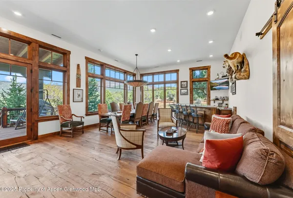 a living room with furniture and floor to ceiling windows