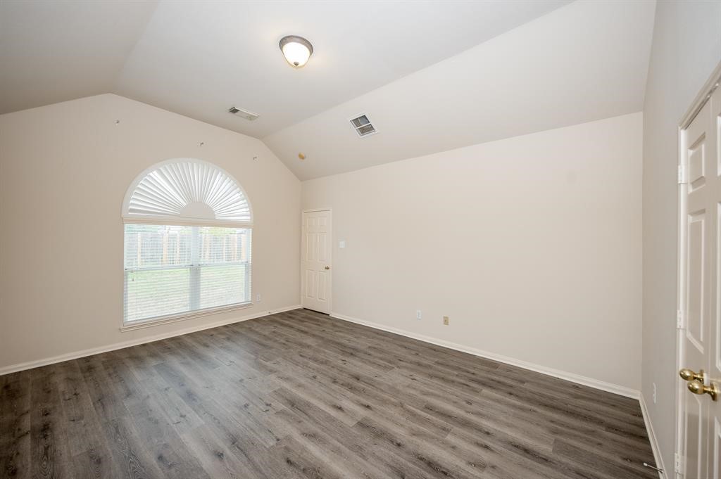 18914 Appletree Ridge Road Houston, TX 77084 - Photo 11 of 31 an empty room with wooden floor and windows