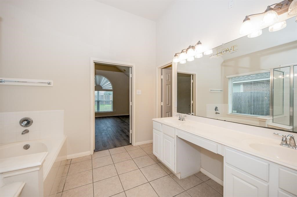 18914 Appletree Ridge Road Houston, TX 77084 - Photo 12 of 31 a bathroom with a sink a mirror and a bathtub