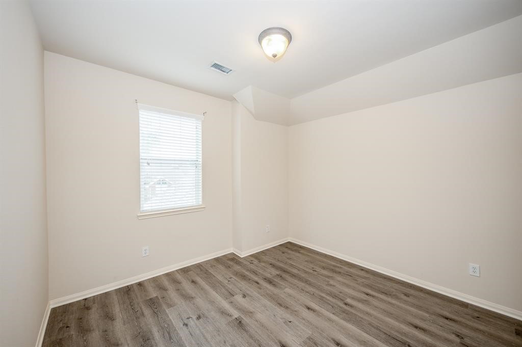 18914 Appletree Ridge Road Houston, TX 77084 - Photo 16 of 31 an empty room with wooden floor and windows