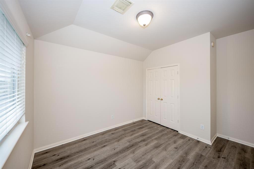 18914 Appletree Ridge Road Houston, TX 77084 - Photo 21 of 31 an empty room with wooden floor and windows