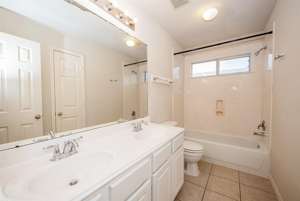 18914 Appletree Ridge Road Houston, TX 77084 - Photo 23 of 31 a bathroom with a double vanity sink toilet mirror and shower