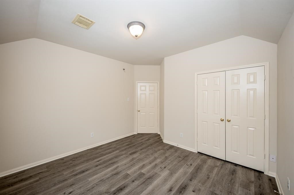 18914 Appletree Ridge Road Houston, TX 77084 - Photo 25 of 31 an empty room with wooden floor and closet