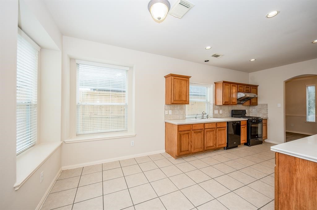 18914 Appletree Ridge Road Houston, TX 77084 - Photo 7 of 31 a large white kitchen with a stove a sink dishwasher and a refrigerator