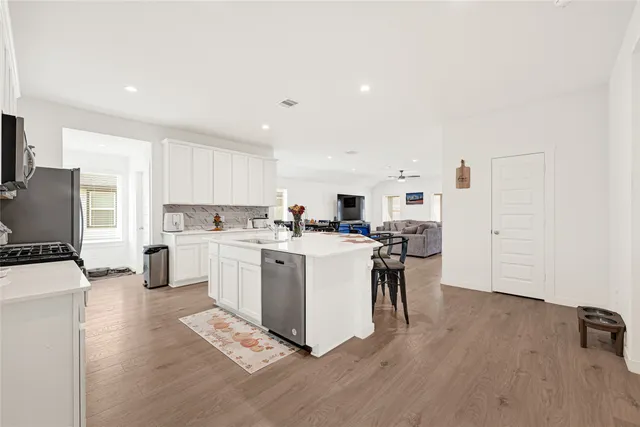 a kitchen with stainless steel appliances granite countertop a sink stove refrigerator and cabinets
