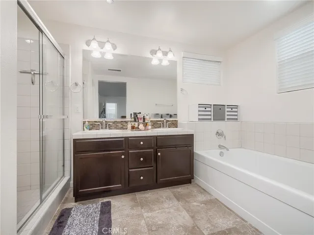 a spacious bathroom with a tub sink and mirror