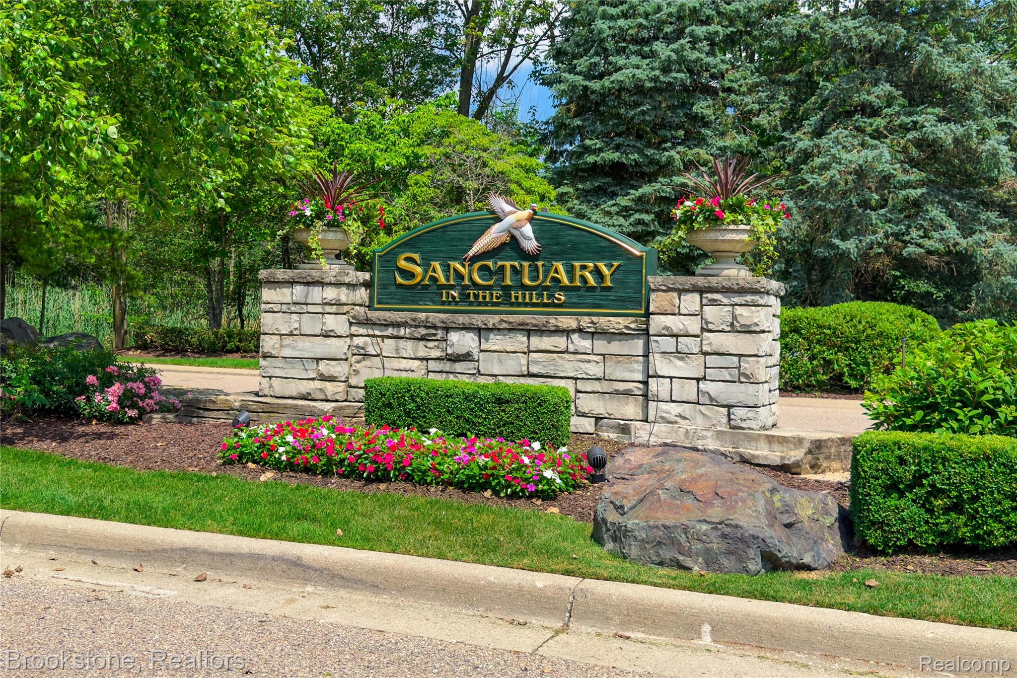 2167 Sanctuary Court Rochester, MI 48309 - Photo 68 of 68 Stone masonry entrance sign featuring raised gold lettering and a decorative avian accent