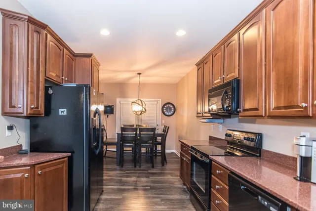 a kitchen with stainless steel appliances granite countertop wooden cabinets a stove top oven a sink and dishwasher