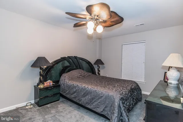 a living room with furniture a rug and wall painting