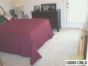 21245 Cold Spring Lane Cornelius, NC 28031 - Photo 5 of 8 a bed sitting in a bedroom next to a bathroom