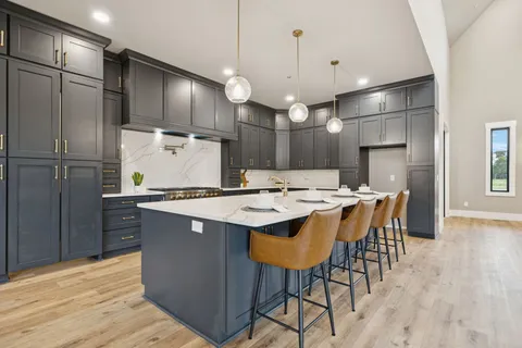 a dining room with wooden floor a chandelier a wooden table and chairs