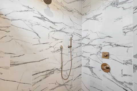 a bathroom with a granite countertop sink toilet and shower