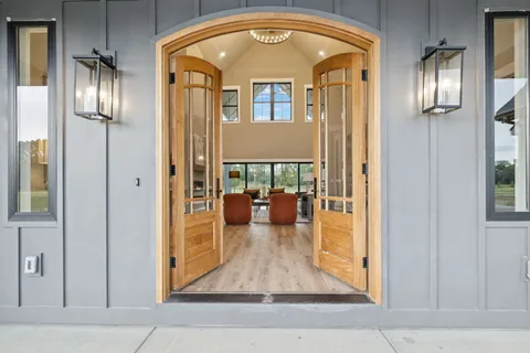 a view of a hallway with wooden floor and a living room