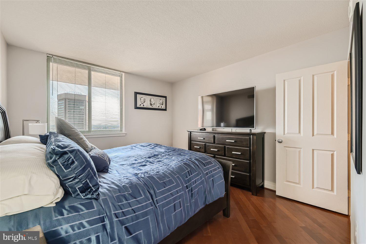 414 Water Street, Unit 2302 Baltimore, MD 21202 - Photo 11 of 34 a bedroom with a bed and a flat screen tv