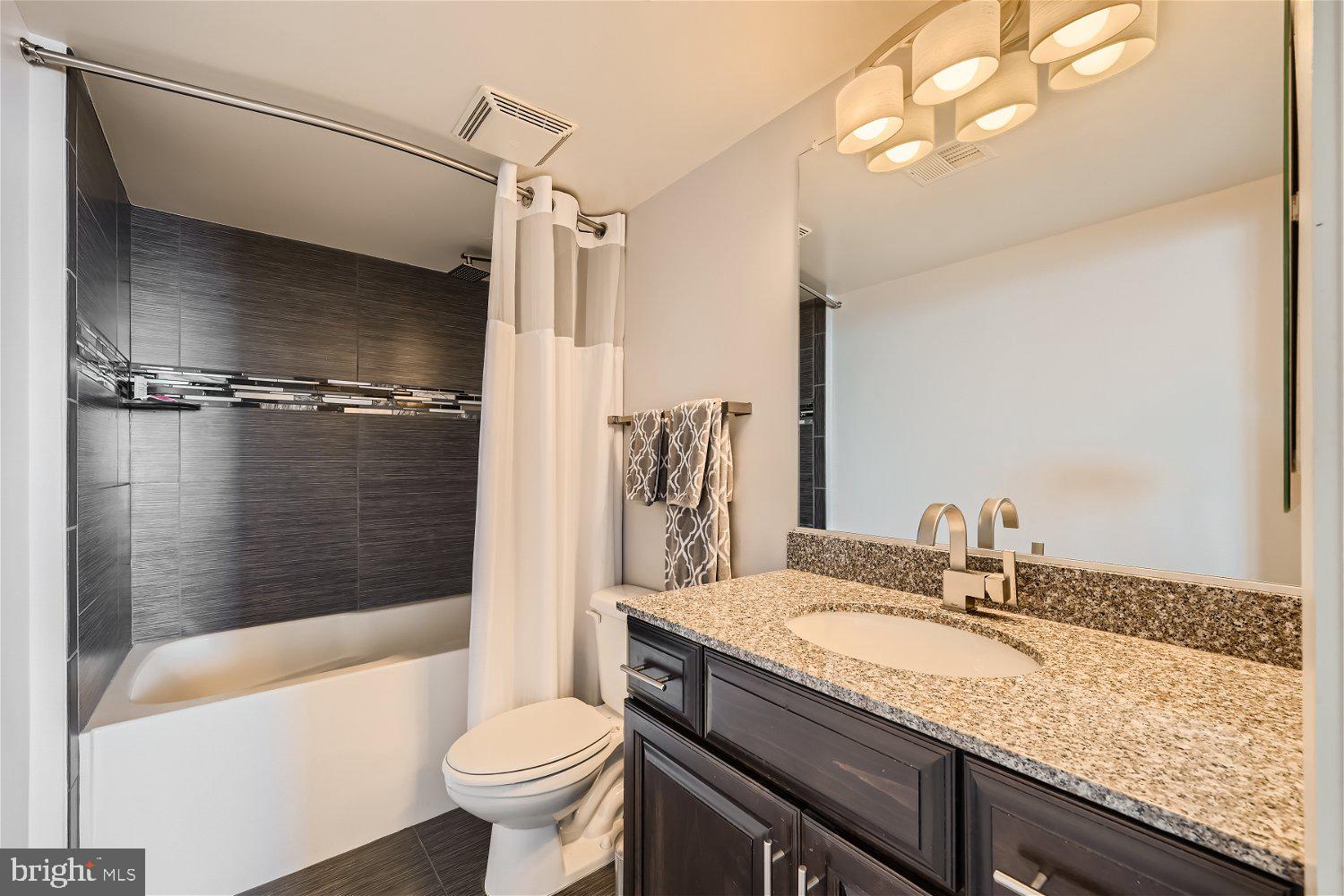 414 Water Street, Unit 2302 Baltimore, MD 21202 - Photo 12 of 34 a bathroom with a granite countertop sink toilet and shower