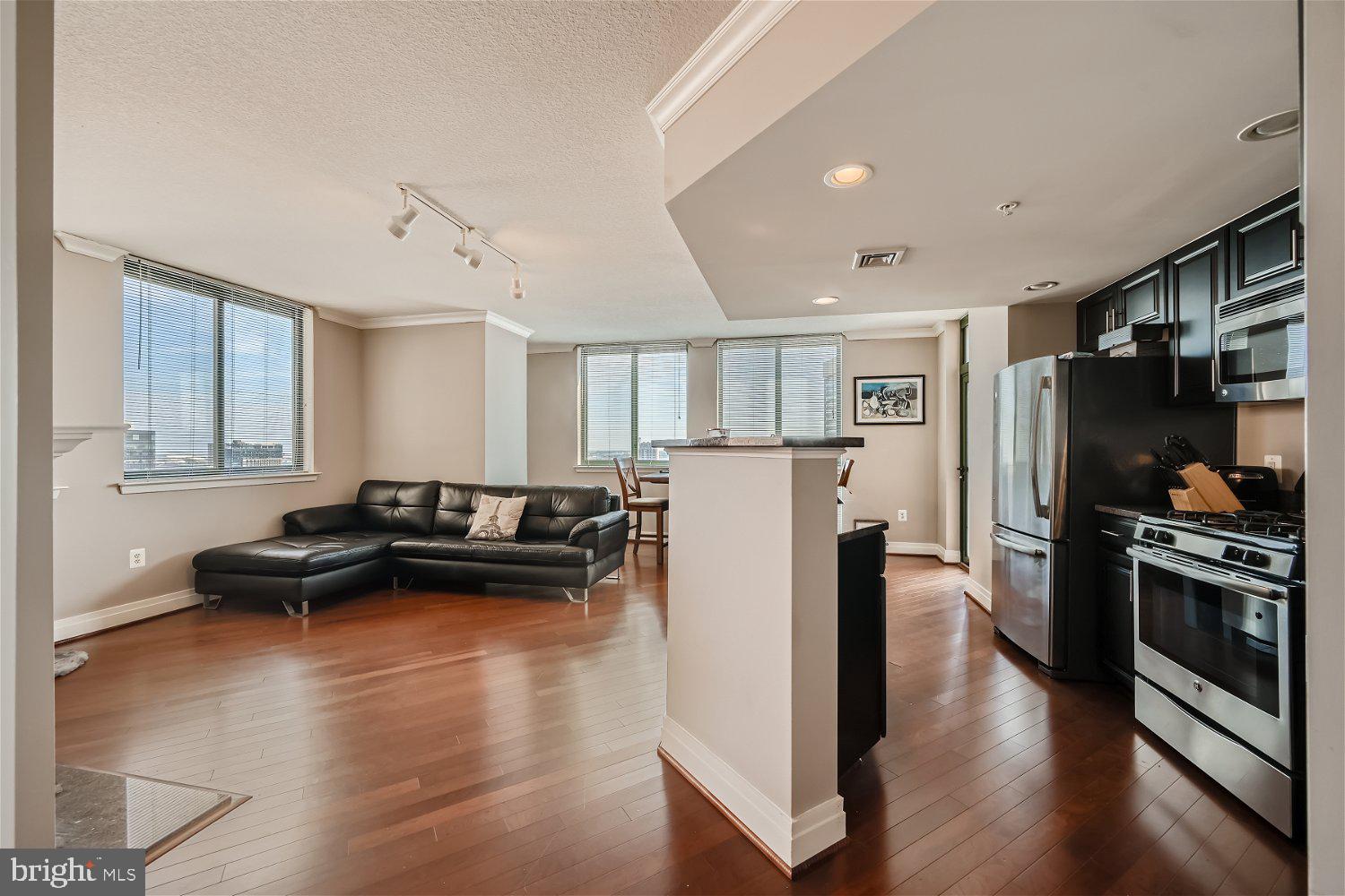 414 Water Street, Unit 2302 Baltimore, MD 21202 - Photo 3 of 34 a living room with furniture windows and a wooden floor