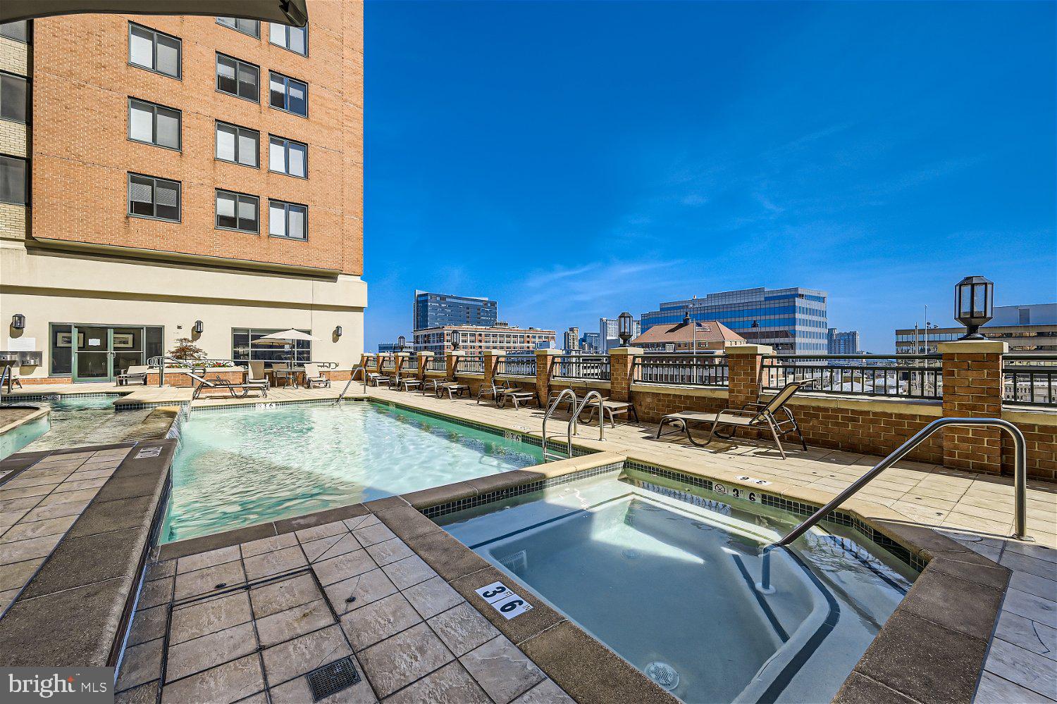 414 Water Street, Unit 2302 Baltimore, MD 21202 - Photo 31 of 34 a view of a swimming pool with a lounge chairs