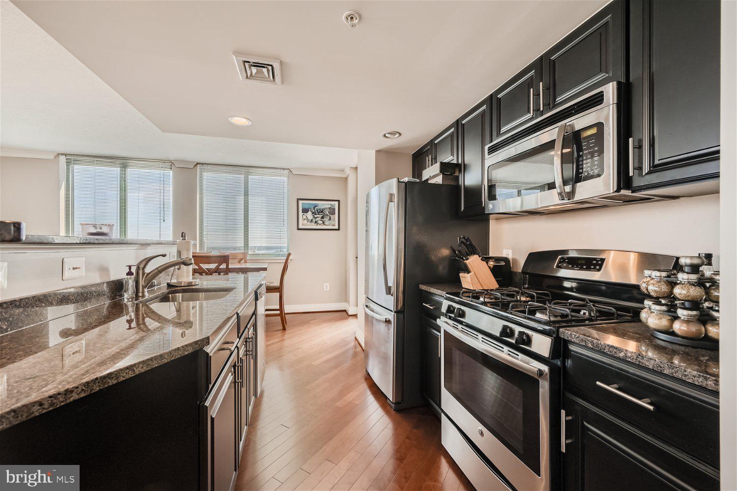 414 Water Street, Unit 2302 Baltimore, MD 21202 - Photo 4 of 34 a kitchen with stainless steel appliances granite countertop a stove a sink dishwasher a refrigerator and a microwave