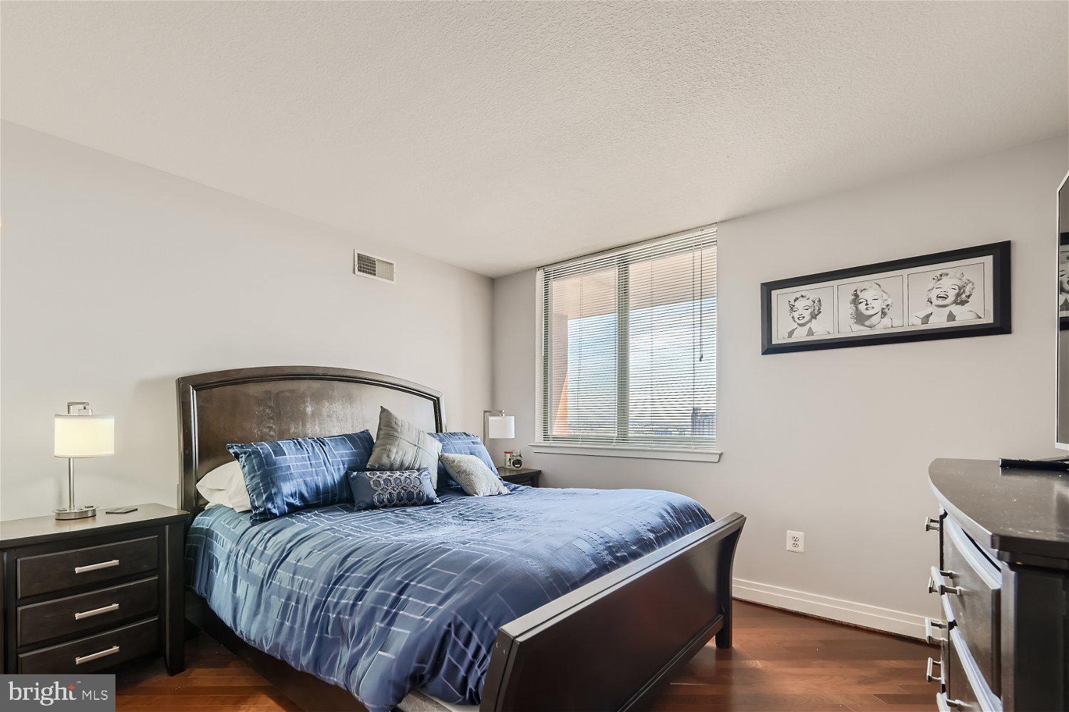 414 Water Street, Unit 2302 Baltimore, MD 21202 - Photo 10 of 34 a bedroom with a bed and wooden floor