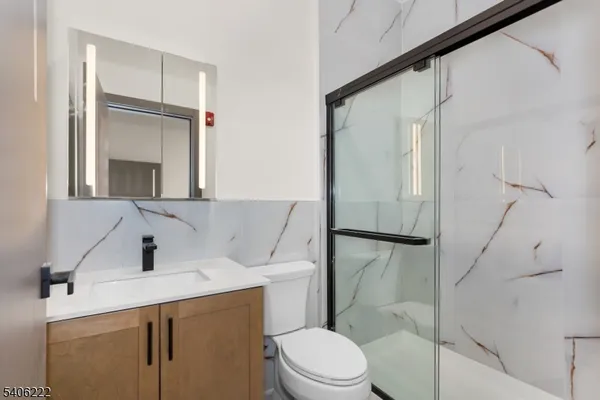 a bathroom with a sink a toilet and shower