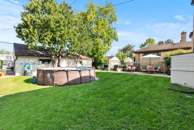 a view of a house with backyard and a tree