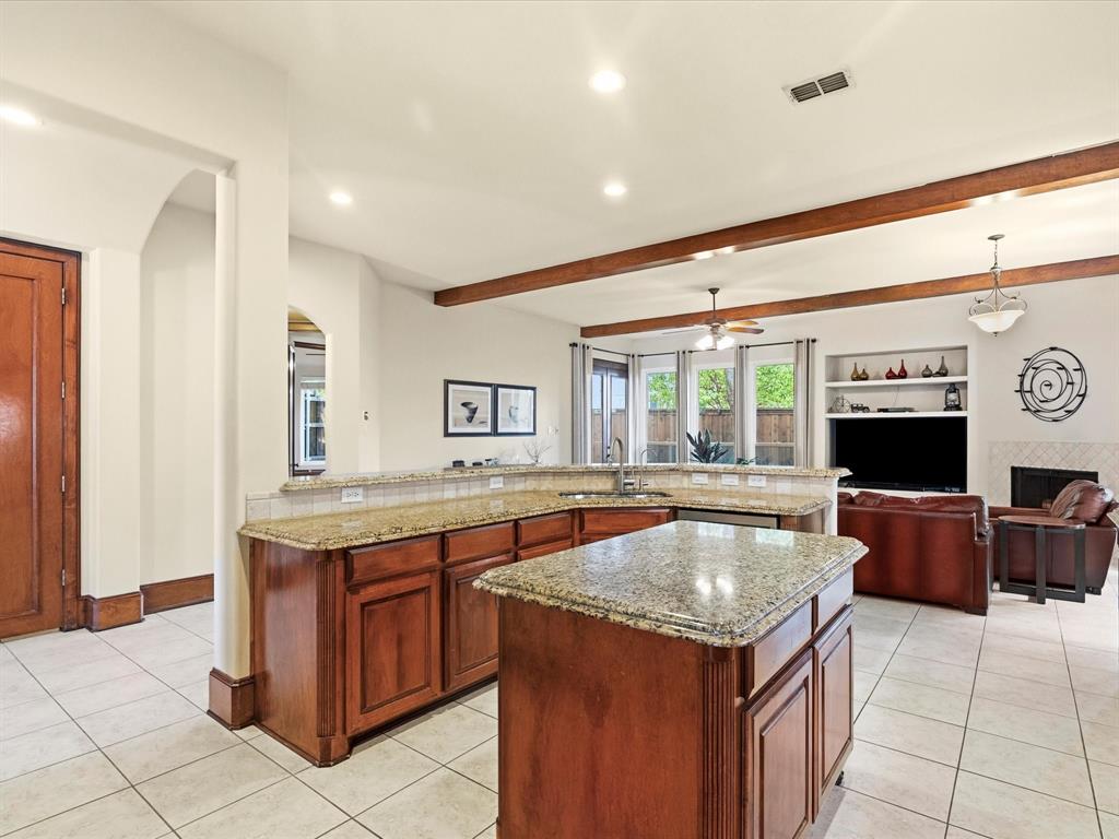1615 Roma Lane Allen, TX 75013 - Photo 9 of 36 Kitchen island featuring granite countertops and wood cabinetry