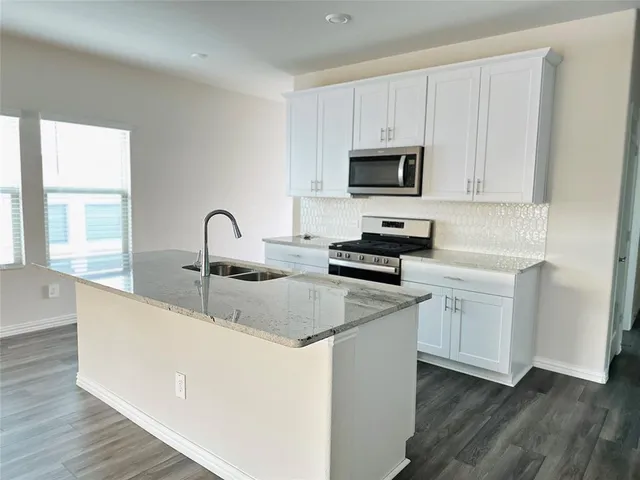 a kitchen with appliances a sink and a stove top oven