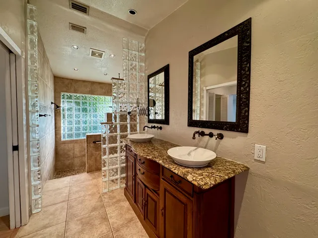 a bathroom with a granite countertop sink and a mirror