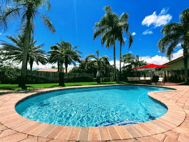 a view of swimming pool with palm trees