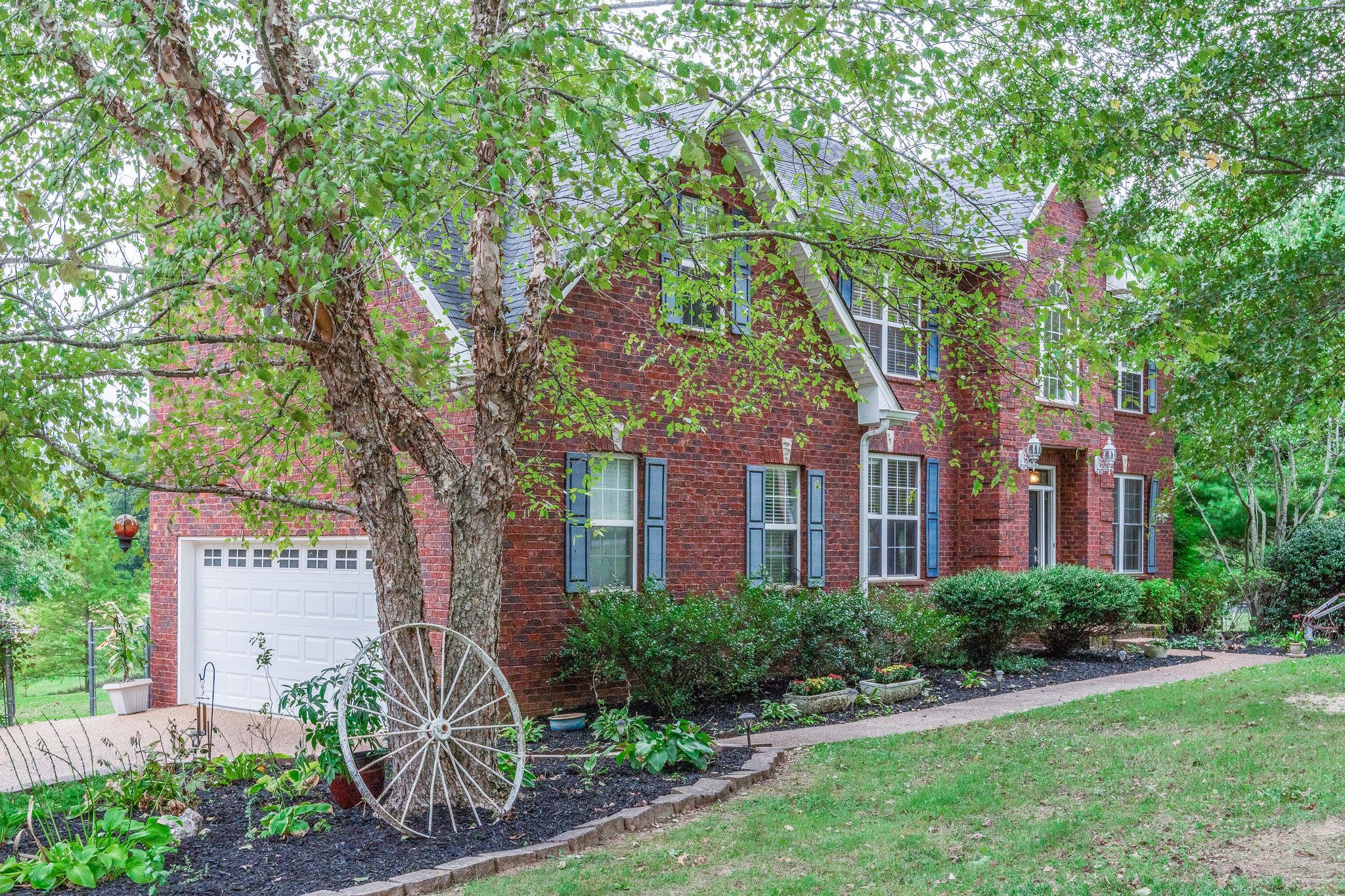 1256 Camp Ravine Road Burns, TN 37029 - Photo 3 of 29 a front view of a house with garden