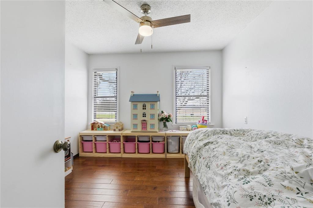 9213 Wilson Road Pilot Point, TX 76258 - Photo 21 of 36 Bedroom featuring wood-finish flooring, dual windows with blinds, a ceiling fan with integrated lighting, and a neutral wall palette