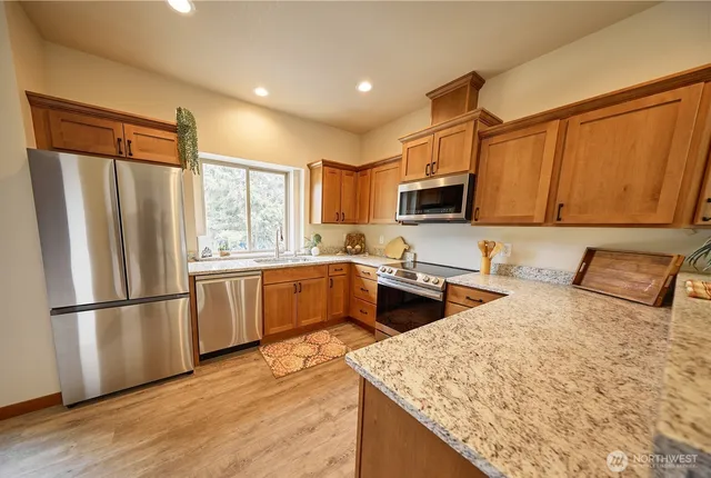 a kitchen with stainless steel appliances granite countertop a refrigerator stove microwave and sink