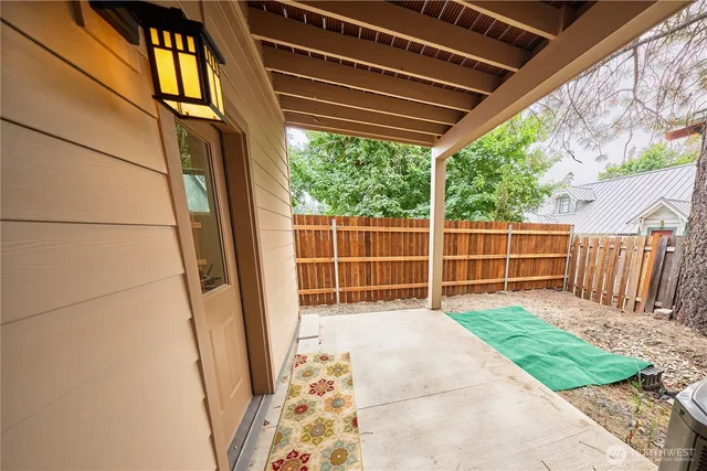 a view of a house with a small yard and wooden fence
