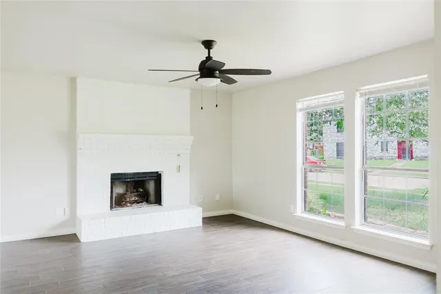 a view of main area fire place window and wooden floor