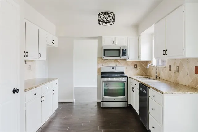 a kitchen with stainless steel appliances a stove a sink and a refrigerator