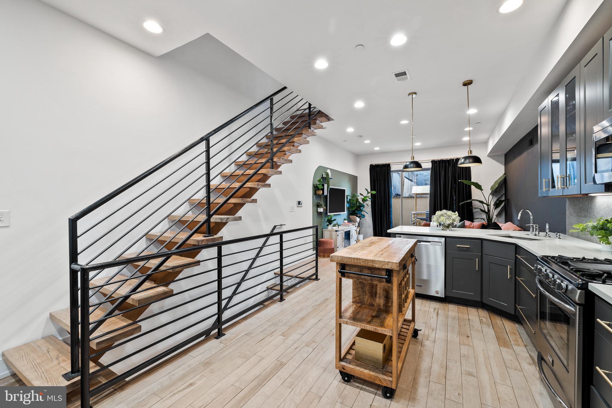 1514 Palethorp Street Philadelphia, PA 19122 - Photo 5 of 41 a kitchen with a table chairs wooden floors and a view of living room