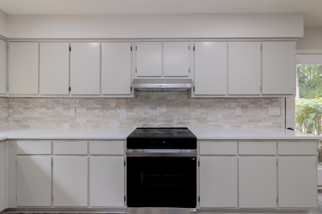 8585 McKee Road Upatoi, GA 31829 - Photo 15 of 62 a kitchen with white cabinets and white appliances
