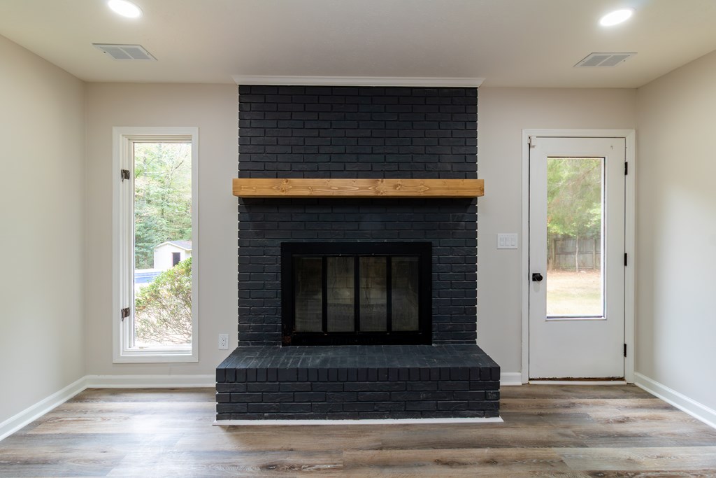 8585 McKee Road Upatoi, GA 31829 - Photo 19 of 62 a living room with fireplace and wooden floor