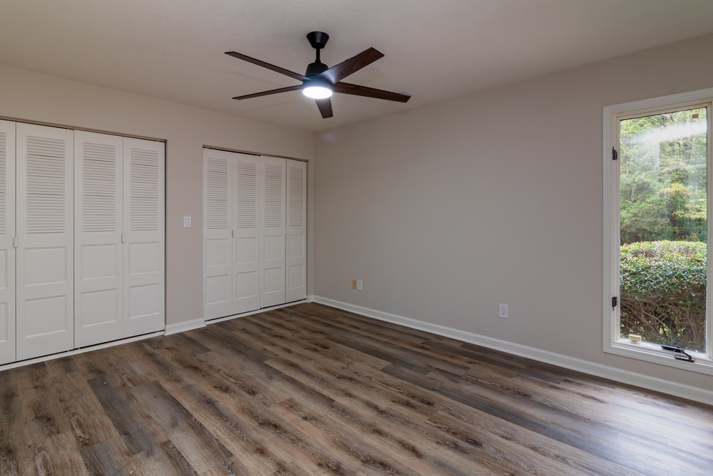 8585 McKee Road Upatoi, GA 31829 - Photo 52 of 62 an empty room with wooden floor fan and windows