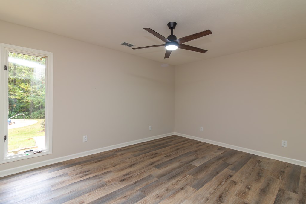 8585 McKee Road Upatoi, GA 31829 - Photo 56 of 62 a view of a big room with wooden floor a ceiling fan and windows