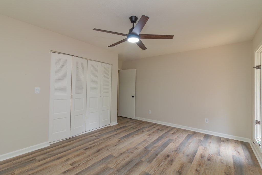 8585 McKee Road Upatoi, GA 31829 - Photo 59 of 62 a view of an empty room with wooden floor and a ceiling fan